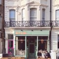 Stem restaurant's green shopfront on Church Road, Hove, with outdoor seating