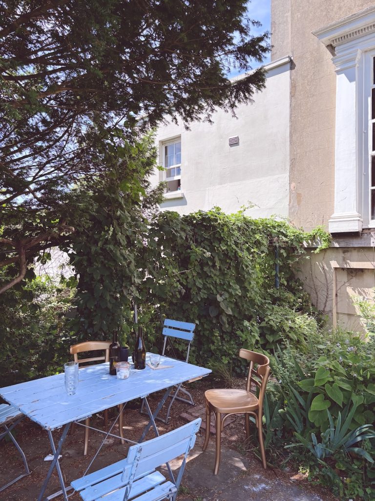 Café Rust at Preston Manor, blue bistro table in a walled garden courtyard