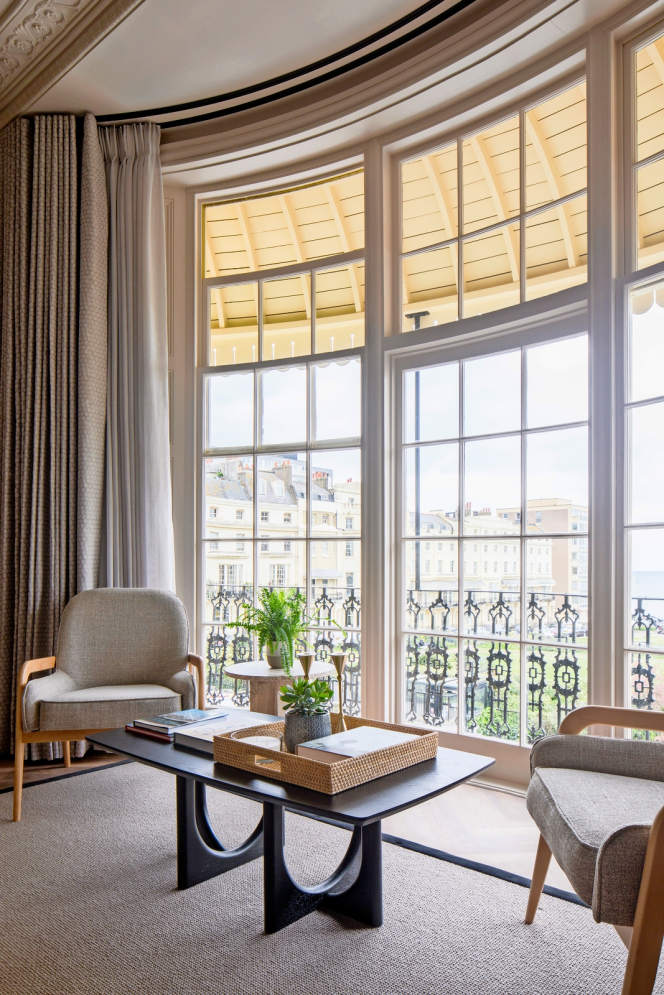 Living area at Regency Square Suites Brighton with large bay windows overlooking Regency Square and the sea