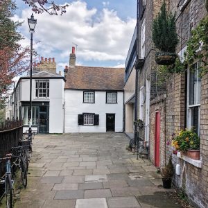 picture of an old white cottage at end of a row