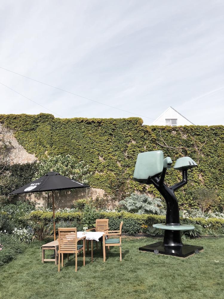 sculptures next to a table an chairs in an old victorian kitchen garden in Brighton 