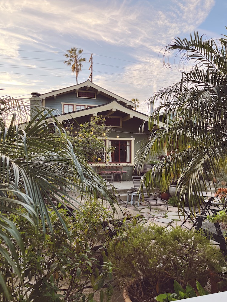 a two story house surrounded by trees along a street in Venice, California