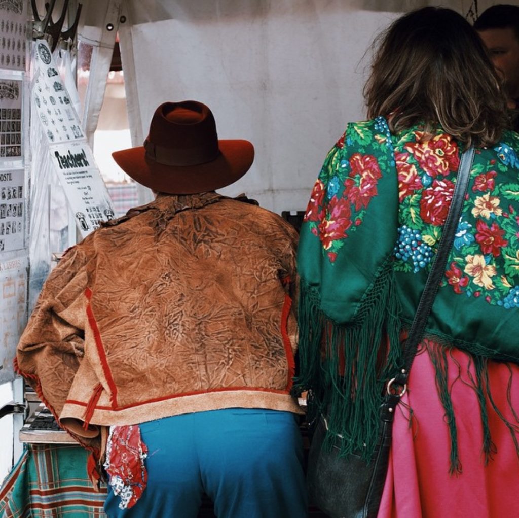 picture of two people facing forwards wearing bright western style clothing