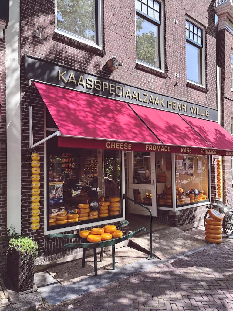 Henri Willig kaasspeciaalzaak cheese shop in Edam with rounds of Edam cheese displayed outside under a red awning, North Holland