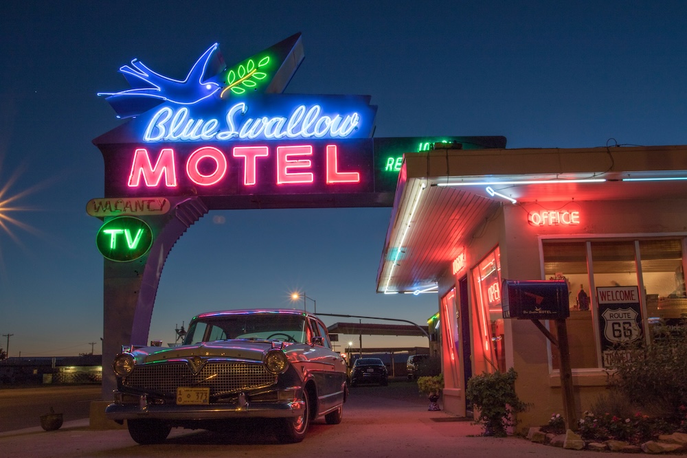 Blue Swallow Motel neon sign and vintage car on Route 66 in Tucumcari, New Mexico