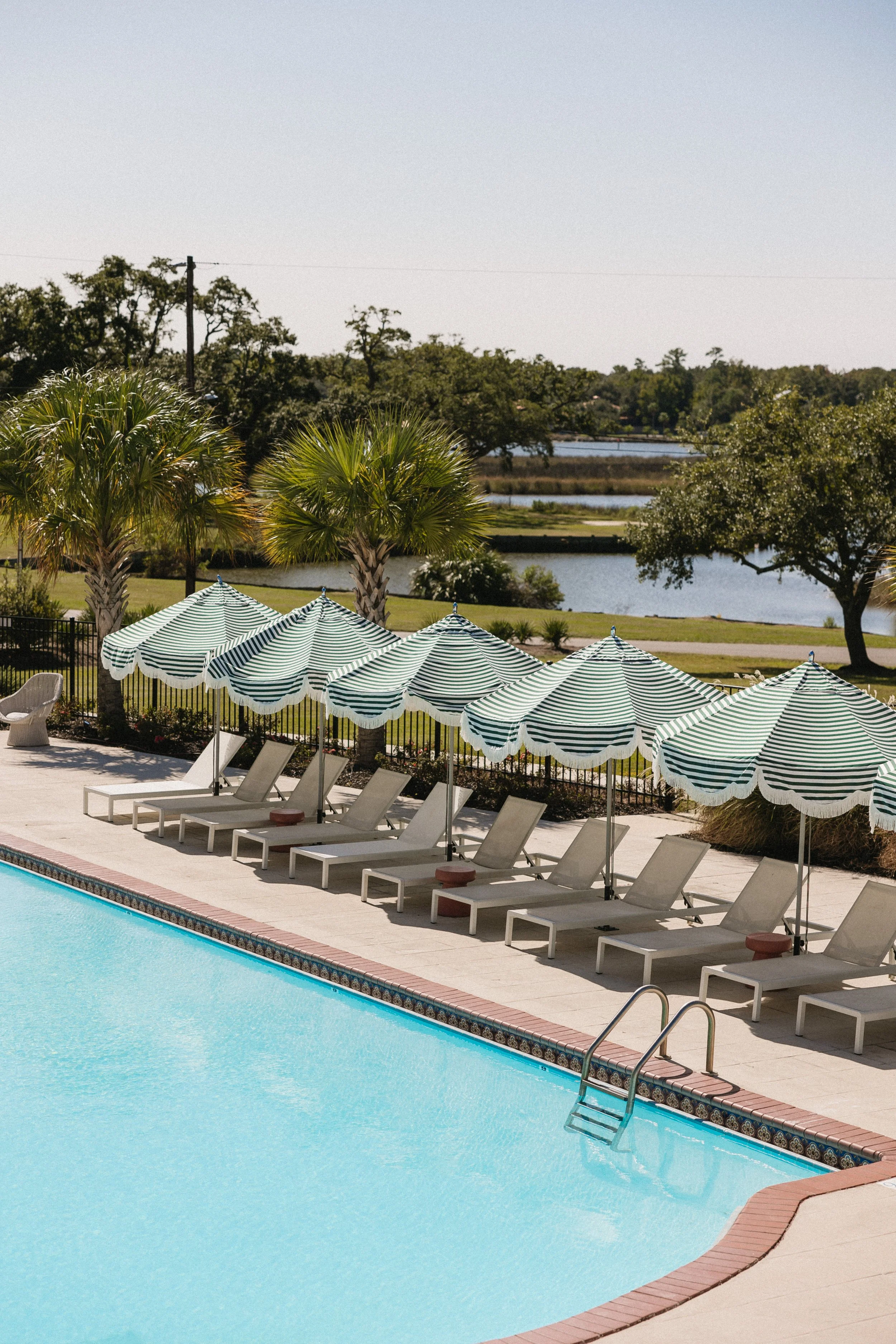 Swimming pool and striped umbrellas at Gulf Hills Hotel & Resort overlooking Fort Bayou in Ocean Springs, Mississippi