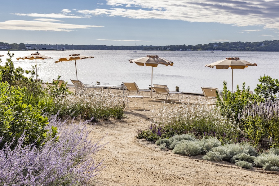 Private sandy beach at Silver Sands Motel & Beach Bungalows in Greenport, New York, with loungers overlooking the bay
